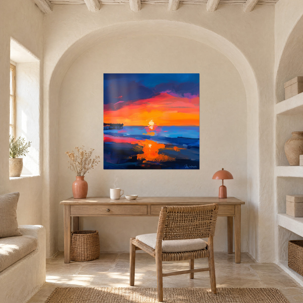 Quadro dipinto a olio di un tramonto, rosa fucsia e blu navy, sopra una scrivania in legno sotto un arco