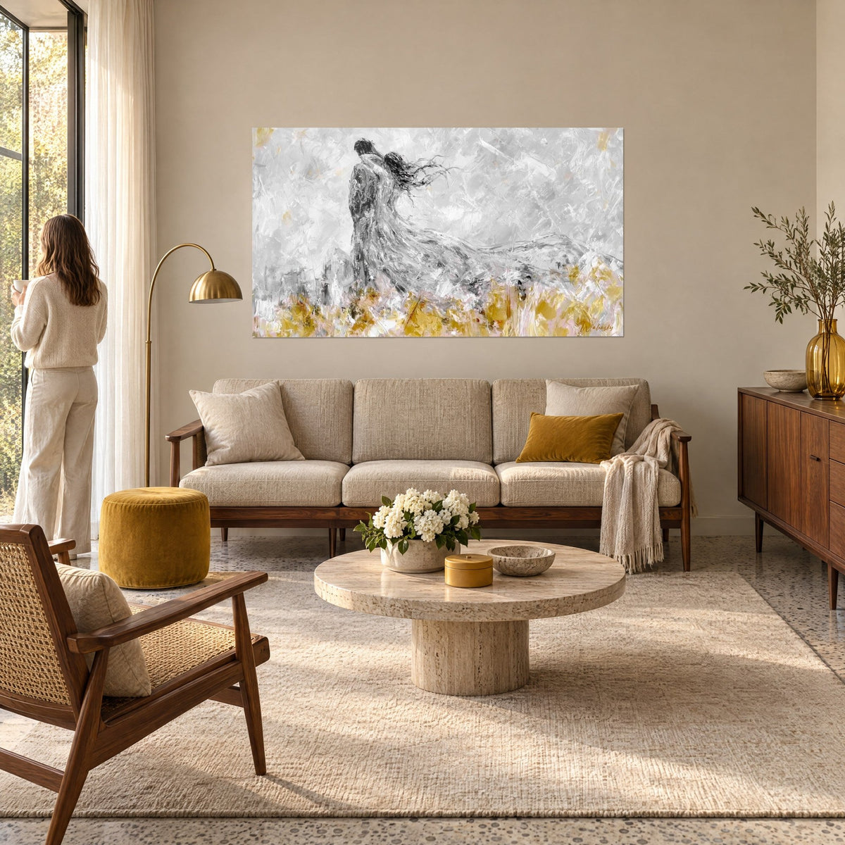 Gemälde eines umschlungenen Liebespaars, graues Kleid im Wind über goldenen Gräsern, zarte rosa Akzente, über einem Sofa in einem hellen Wohnzimmer