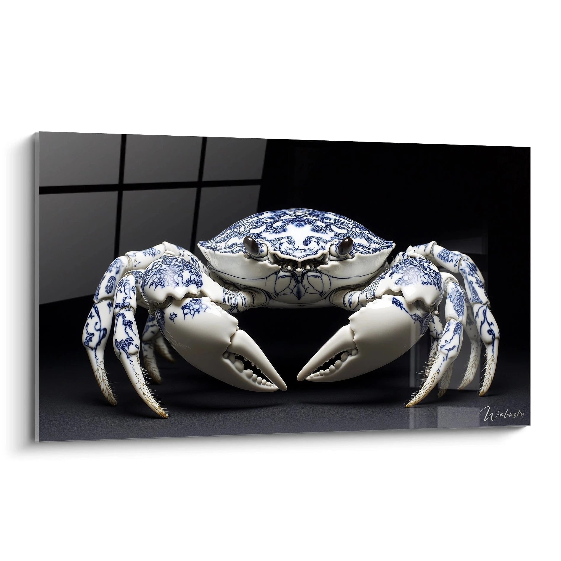 Un tableau crabe en porcelaine blanche décoré de motifs bleu cobalt sur fond noir. Le crustacé, parfaitement symétrique, présente des pinces levées et des pattes finement détaillées avec des ornements floraux bleus sur sa carapace arrondie et brillante.
