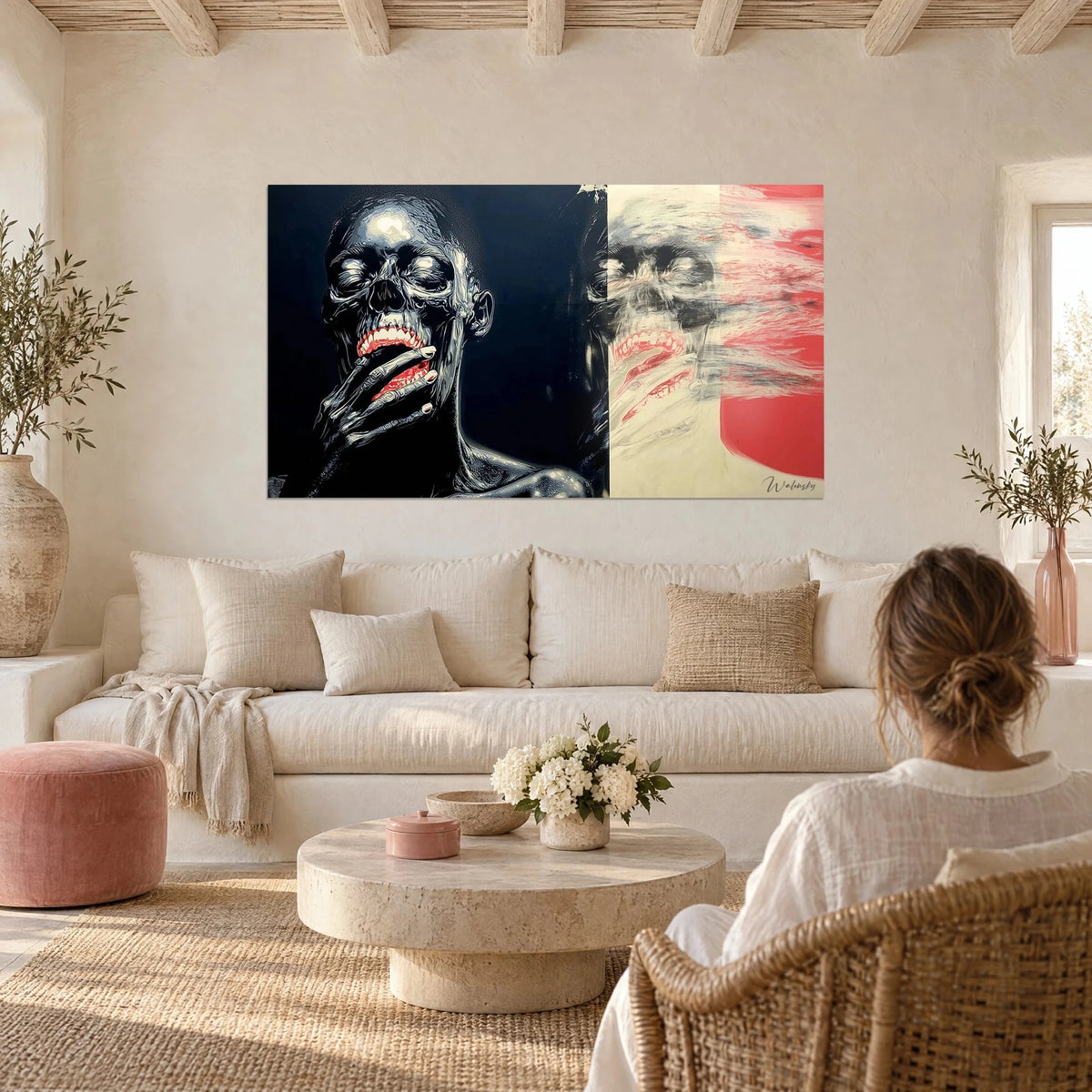 Schilderij zwart-wit doodshoofd met rode lippen, hand voor de mond, boven een bank in een lichte woonkamer