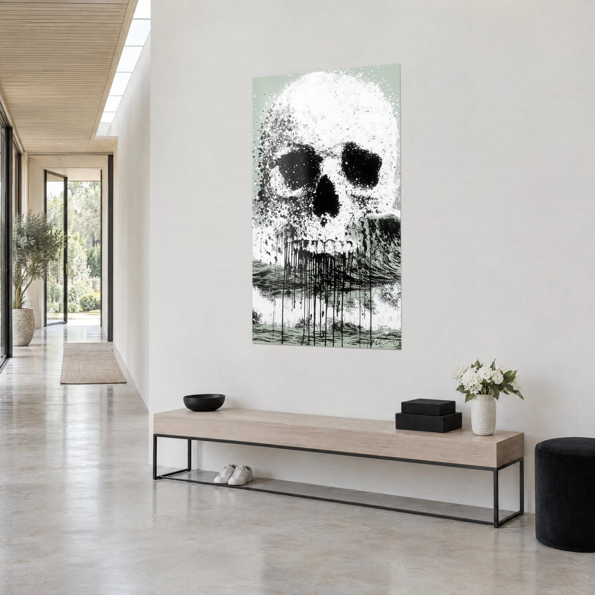 Gemälde Totenkopf in weißer und schwarzer Tinte, graue Welle unter dem Kiefer, im hellen Flur neben einer Holzbank aufgehängt
