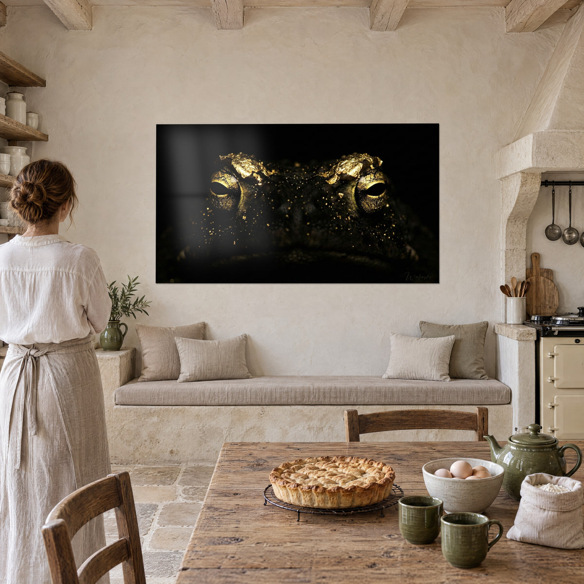 Gemälde Krötenporträt, gehämmerte goldene Augenbrauenbögen und dunkle Haut mit goldenen Punkten, beige Wand neben einem Küchentisch