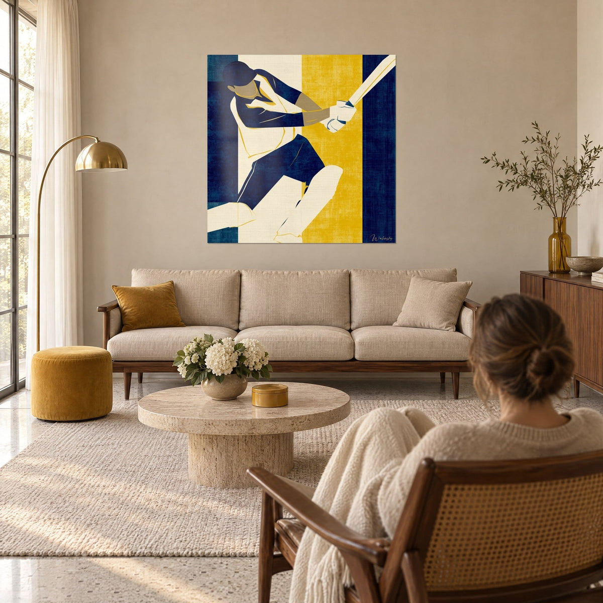 Tableau batteur de cricket en plein swing, bleu marine et ocre doré, une femme de dos au-dessus d'un canapé dans un salon lumineux