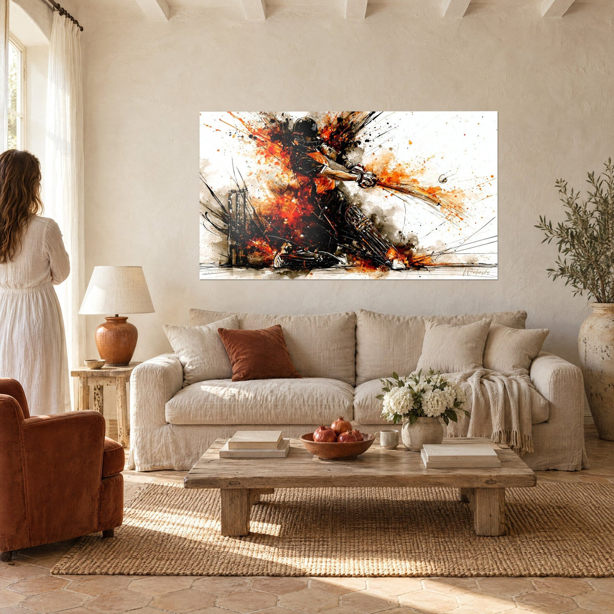 Wall art of a cricket batter mid-swing, orange and black splashes, couple seen from behind, above a sofa in a bright living room