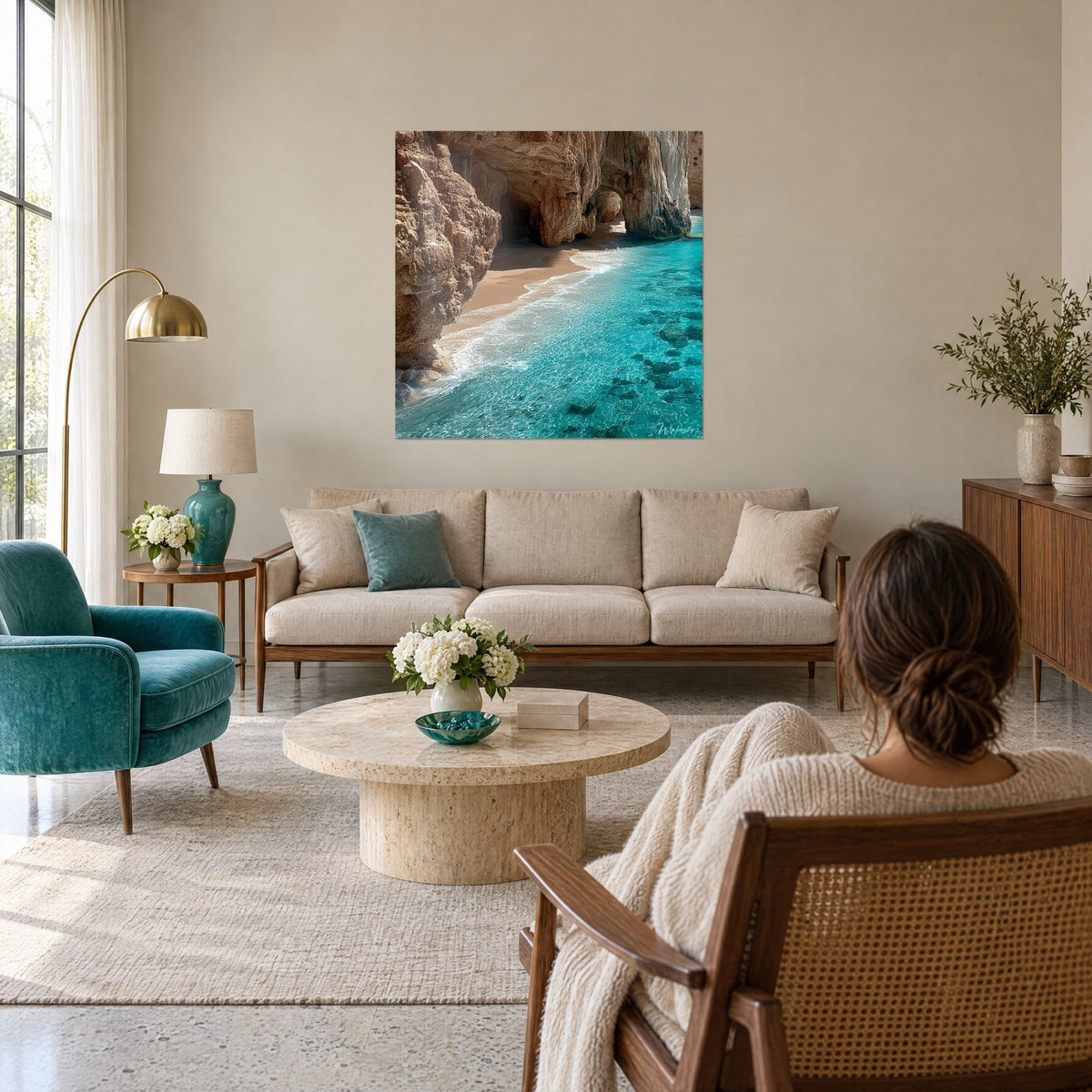 Gemälde Felsbucht mit ockerfarbenen Klippen, die in klares türkisfarbenes Wasser abfallen, über einem Sofa in einem hellen Wohnzimmer