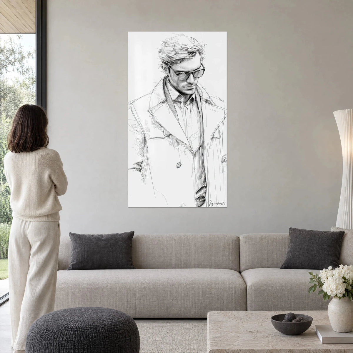 Gemälde Skizze eines Mannes mit getönter Brille, grauer Trenchcoat in Bleistift auf weißem Grund, über einem Sofa in einem hellen Wohnzimmer