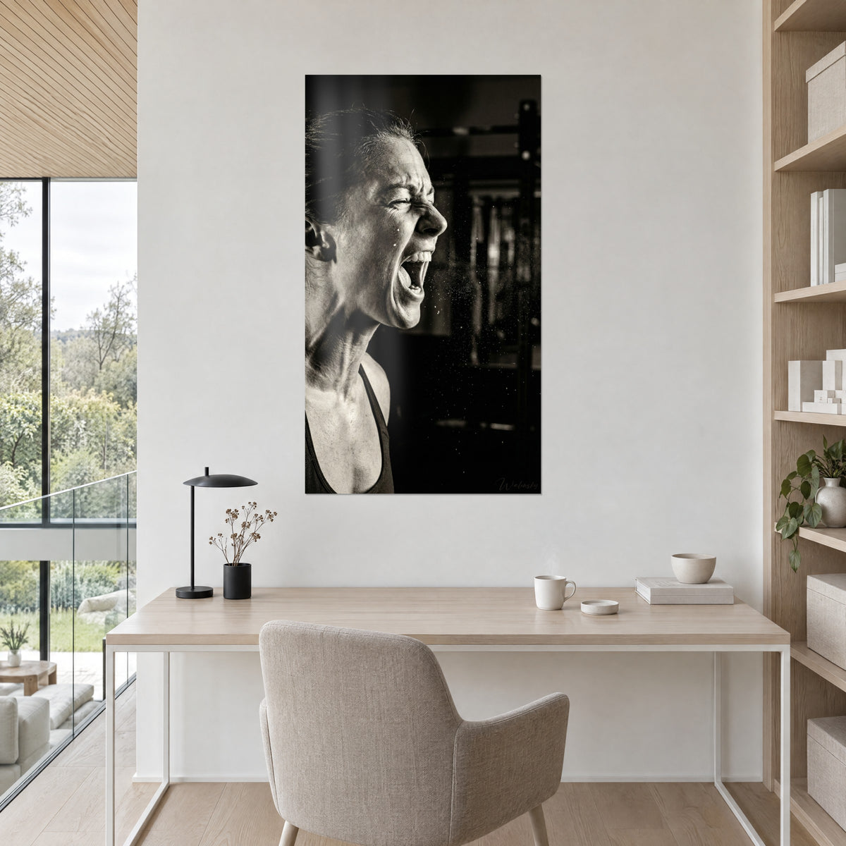 Tableau visage de sportive tendu par l'effort, grain monochrome beige et noir, au-dessus d'un bureau en bois clair près d'un olivier