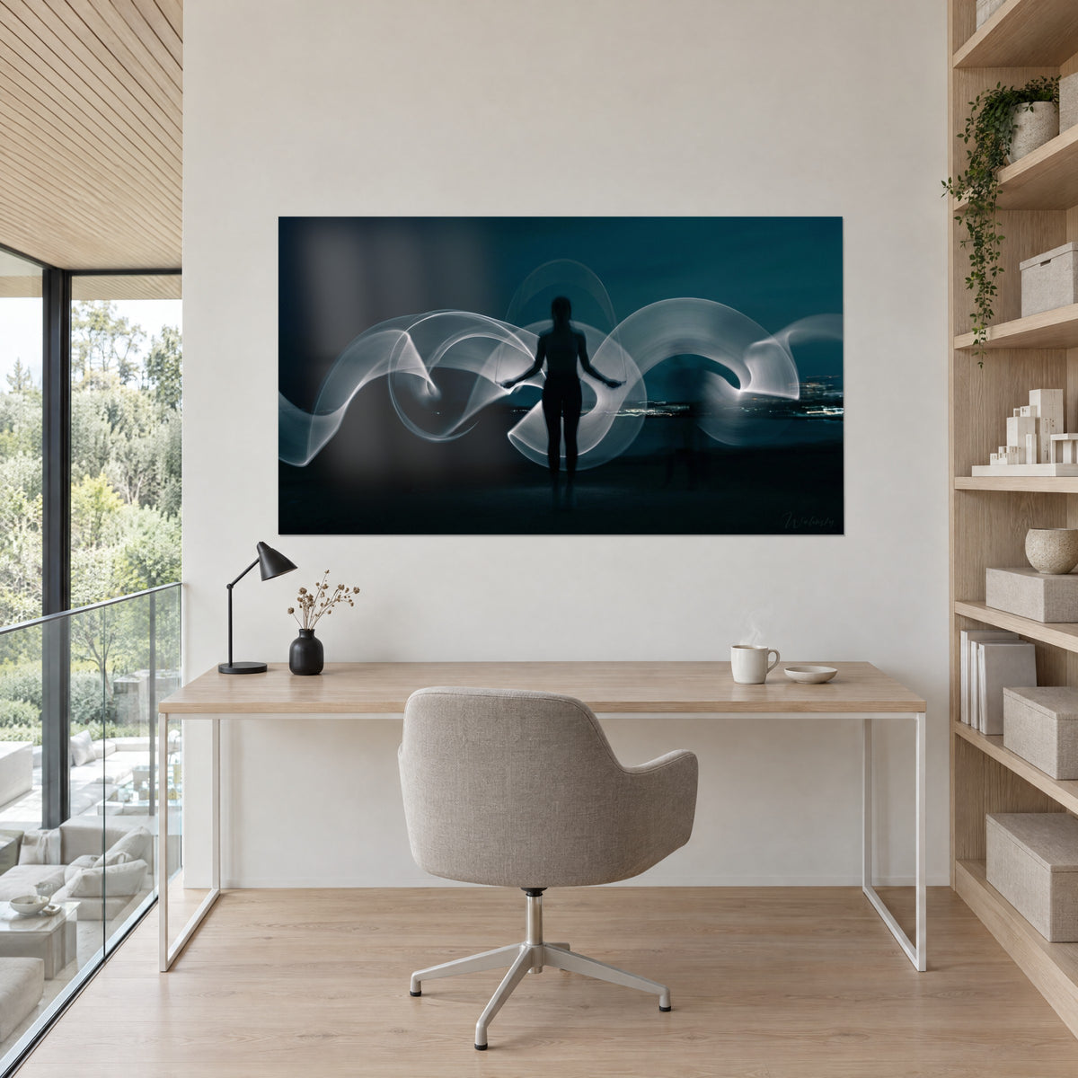 Tableau énergie lumineuse en arabesques blanc nacré sur fond bleu marine, silhouette centrale, accroché au-dessus d'un bureau en bois clair