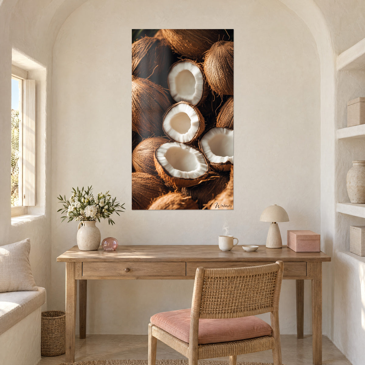 Cuadro de medios cocos crema con hueco nacarado y cáscaras marrón chocolate, en la pared de un despacho de madera clara con silla de cojín rosa