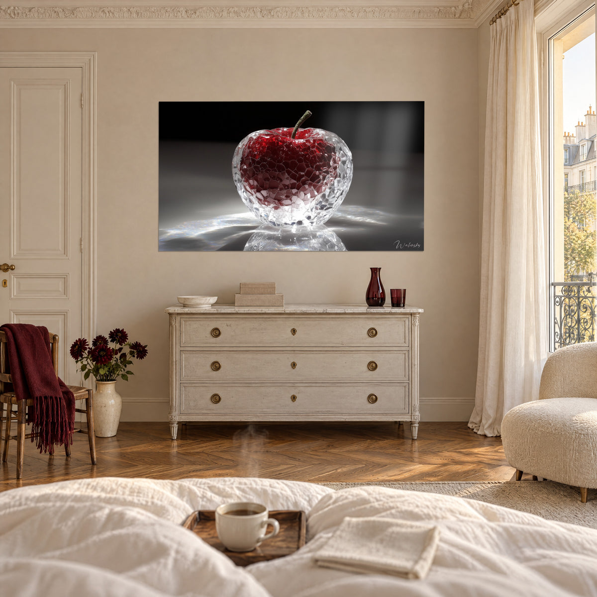 Cuadro escultura de cristal en forma de manzana, rubí profundo en estuche negro, encima de una cama en un dormitorio luminoso