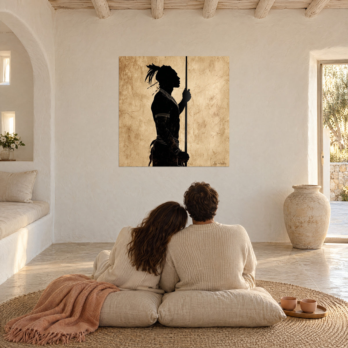 Quadro figura ancestrale di profilo, lunga lancia e piume nere su fondo bruno dorato invecchiato, di fronte a una coppia seduta su cuscini