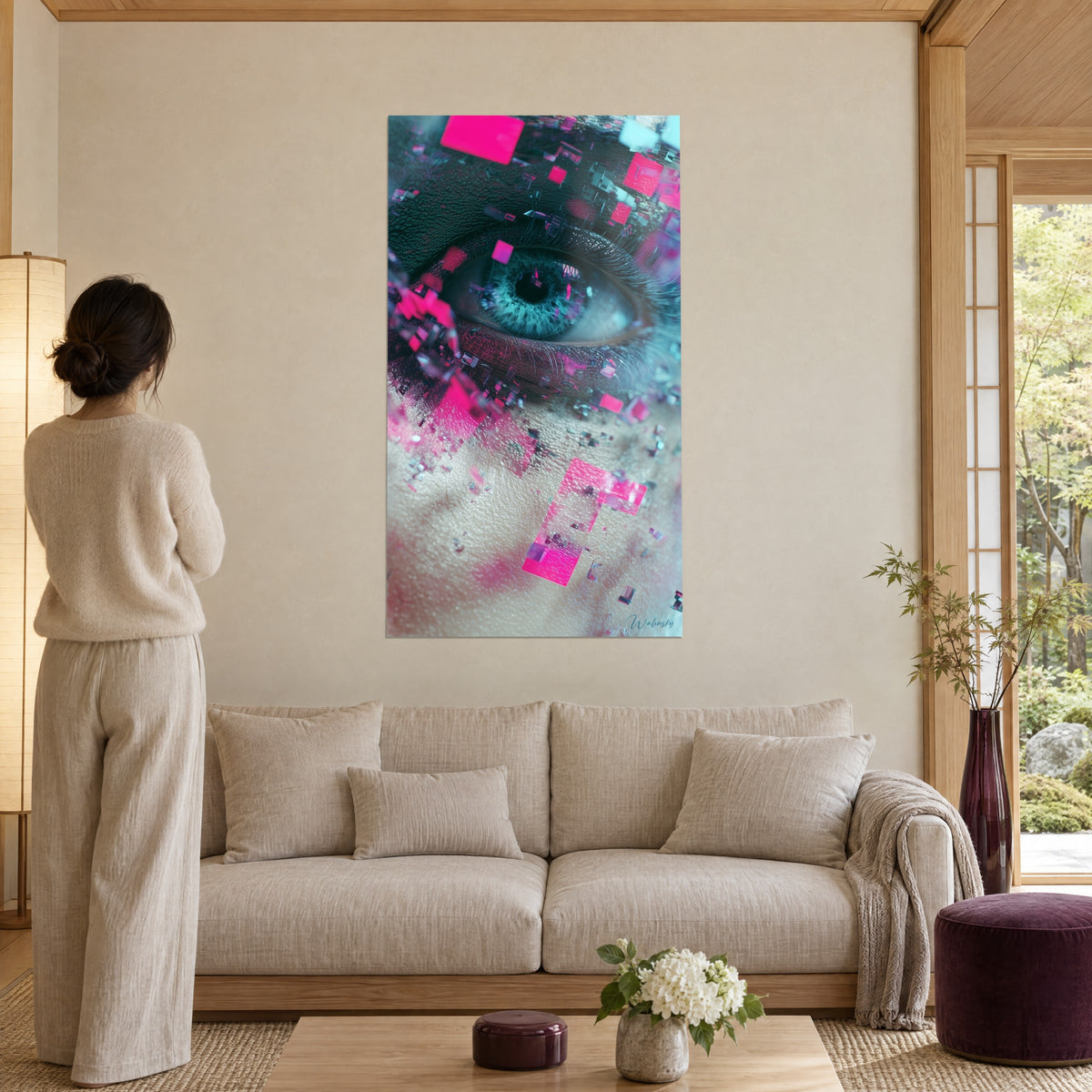 Tableau œil bleu-vert cerné de cils noirs et d'éclats de pixels roses, femme de dos, au-dessus d'un canapé dans un salon lumineux