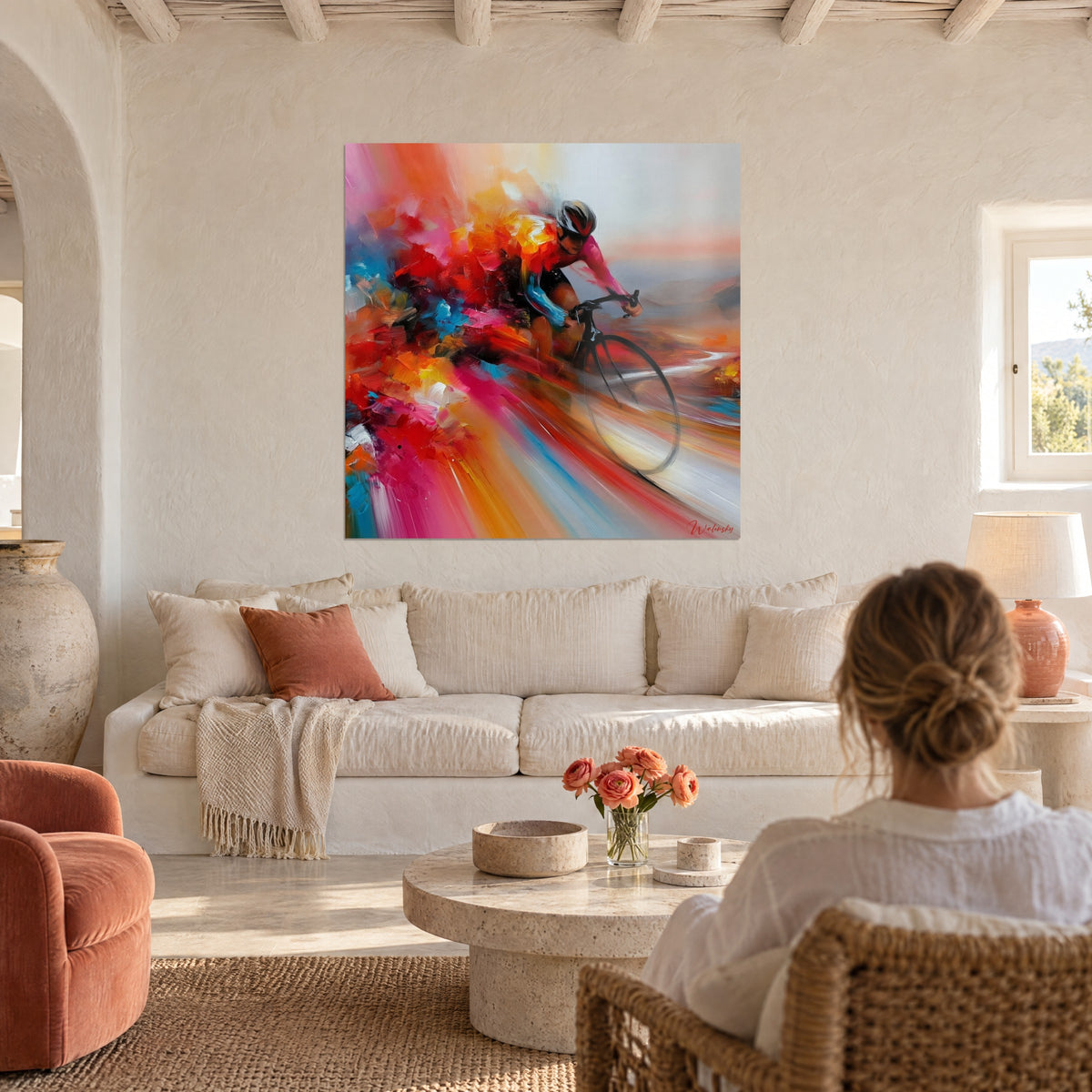 Wall art cyclist in a sprint, pink jersey with blue sleeves in an orange blur, above a sofa in a bright living room