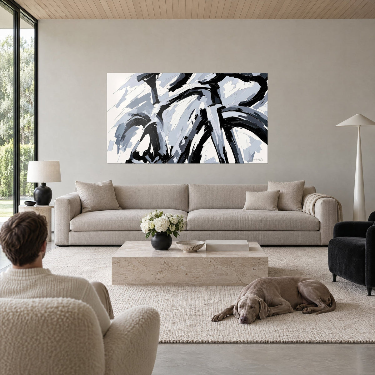 Wall art racing bicycle in black and pearl grey palette-knife strokes, cream background, above a sofa in a bright living room
