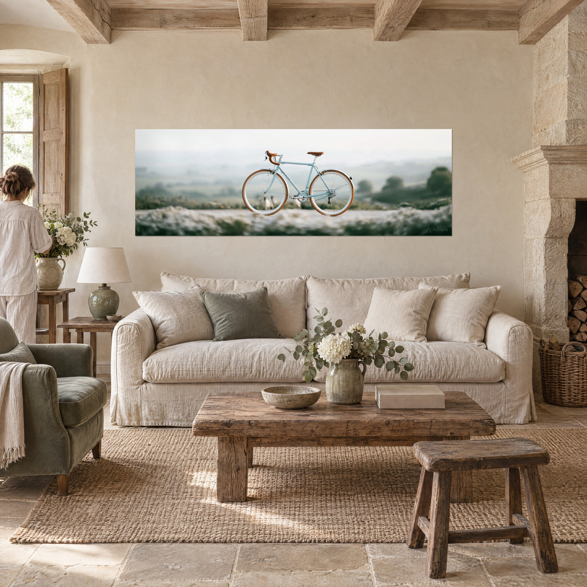 Tableau vélo de route bleu pastel aux pneus miel, brume verte de la campagne, au-dessus d'un canapé dans un salon lumineux