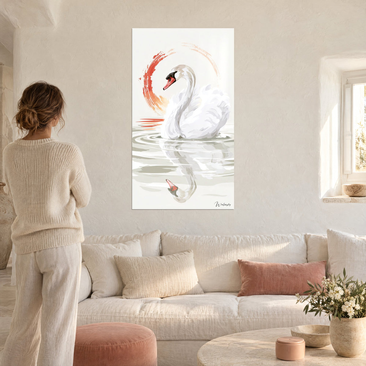 Tableau cygne blanc au long cou gracile, bec corail, cercle peint rouge et orange, femme de dos, au-dessus d'un canapé dans un salon lumineux