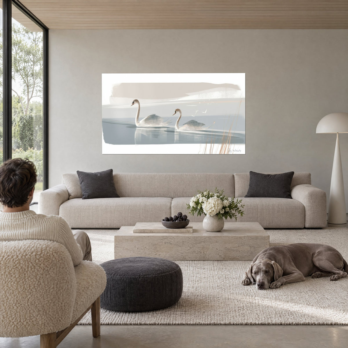 Quadro di una coppia di cigni dal collo sottile che scivolano su un'acqua grigio-azzurra, canne beige, sopra un divano in un soggiorno luminoso