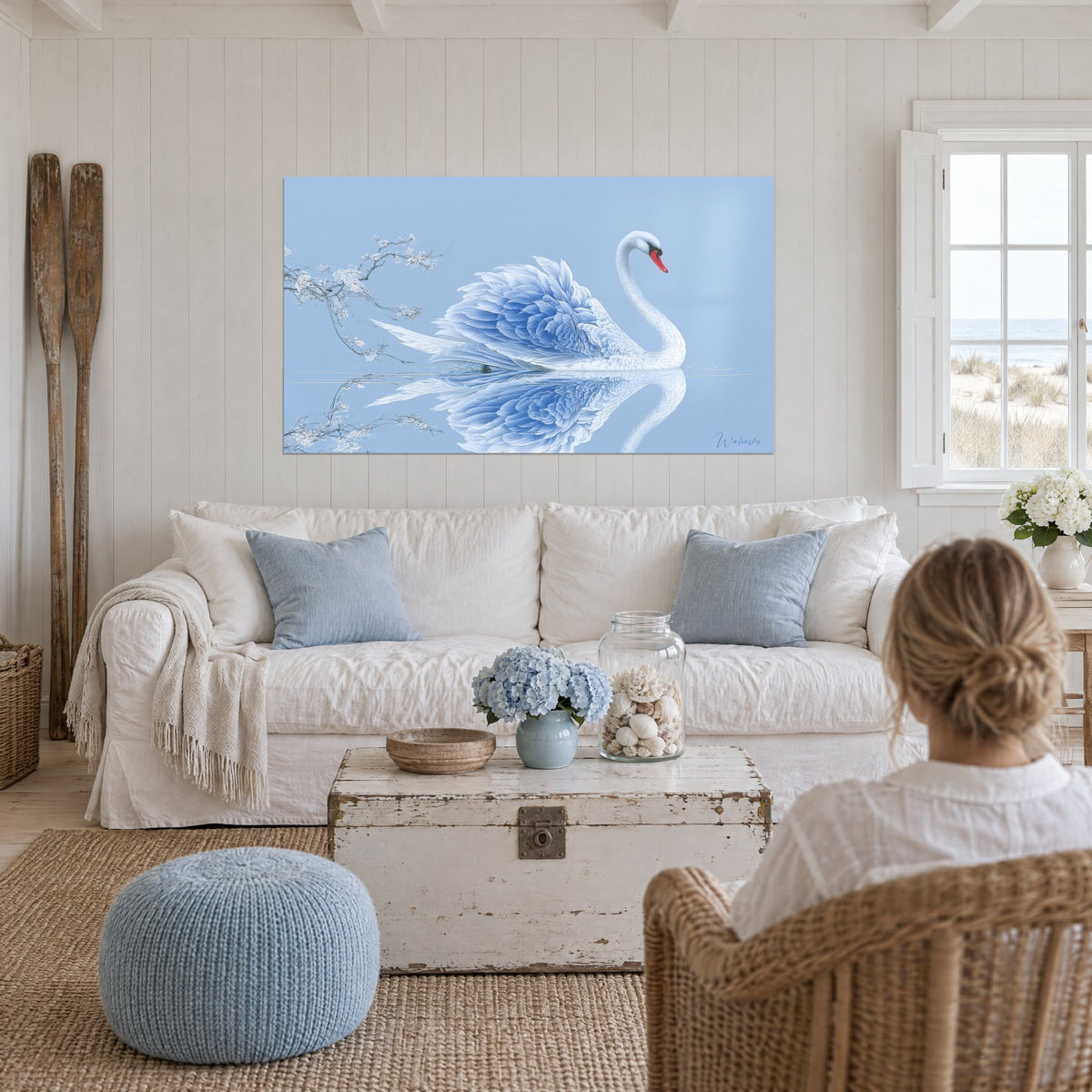 Tableau cygne blanc aux plumes bleu poudré et bec rouge, reflet dans l'eau, au-dessus d'un canapé dans un salon lumineux