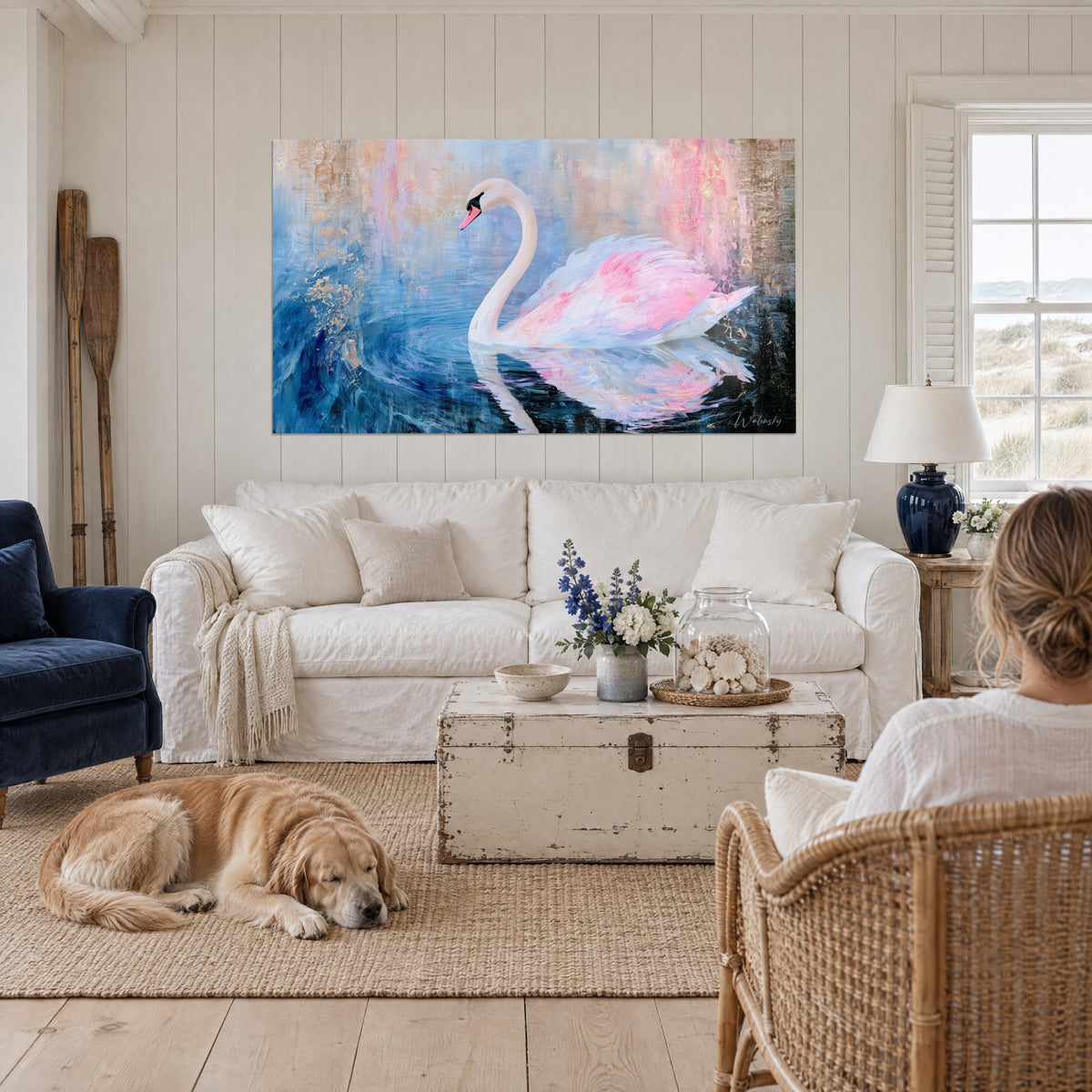 Tableau cygne ivoire glissant sur un lac bleu, plumes rose poudré et reflets dorés, au-dessus d'un canapé dans un salon lumineux