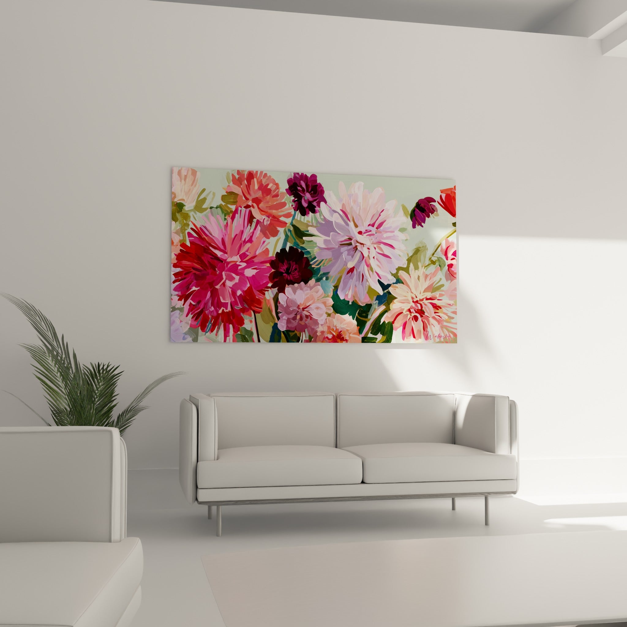 Fleurs de dahlia bordeaux et roses au-dessus d'un canapé dans un salon lumineux