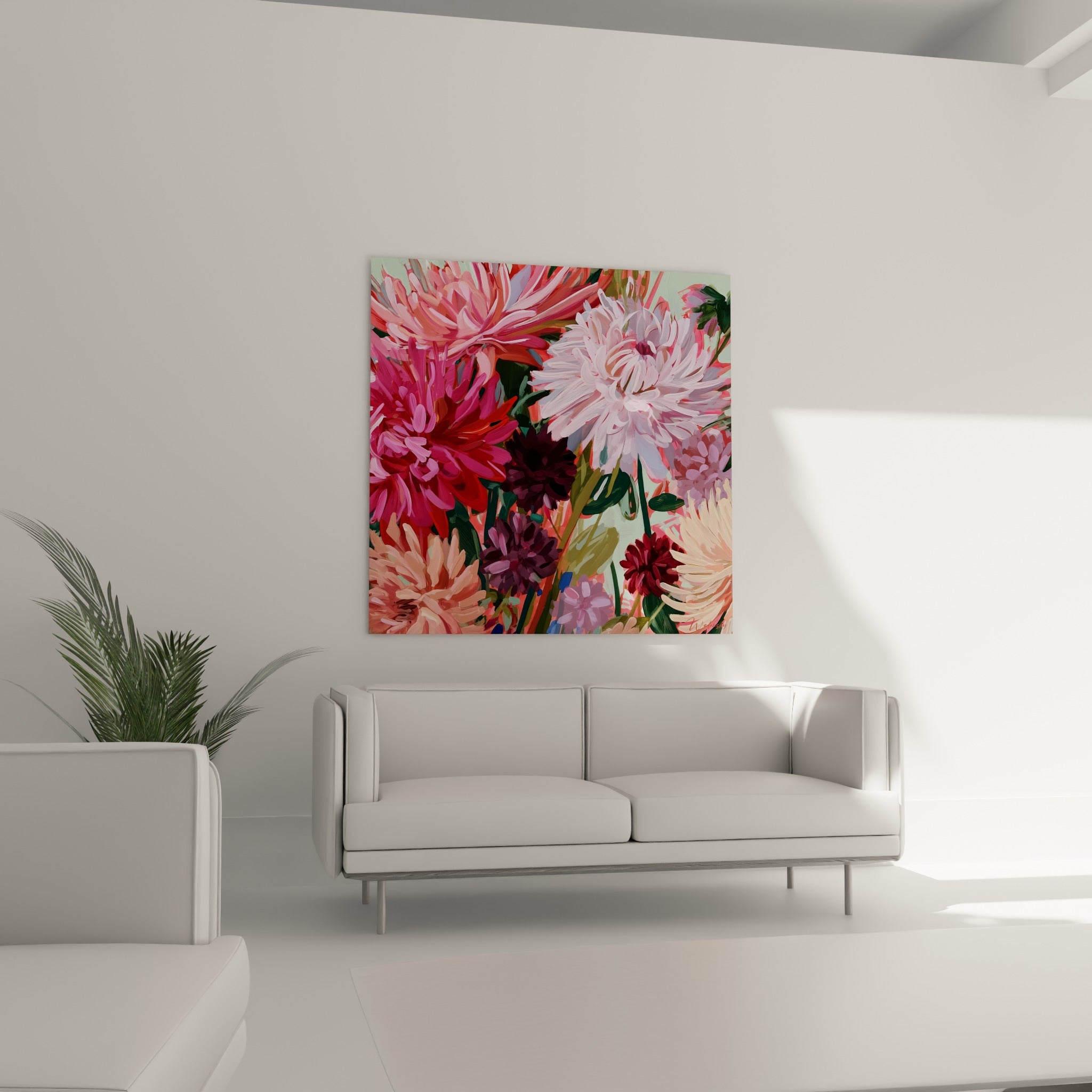 Fleurs de dahlia rose pâle et rouge écarlate au-dessus d'un canapé dans un salon lumineux