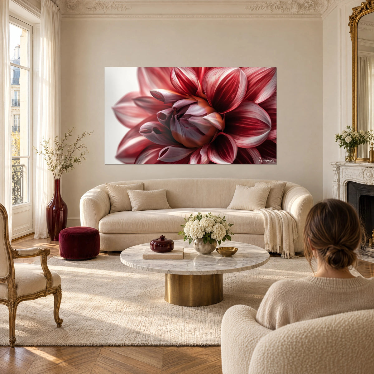 Tableau dahlia rouge cerise aux pétales veinés de rose pâle, accroché au-dessus d'un canapé dans un salon lumineux