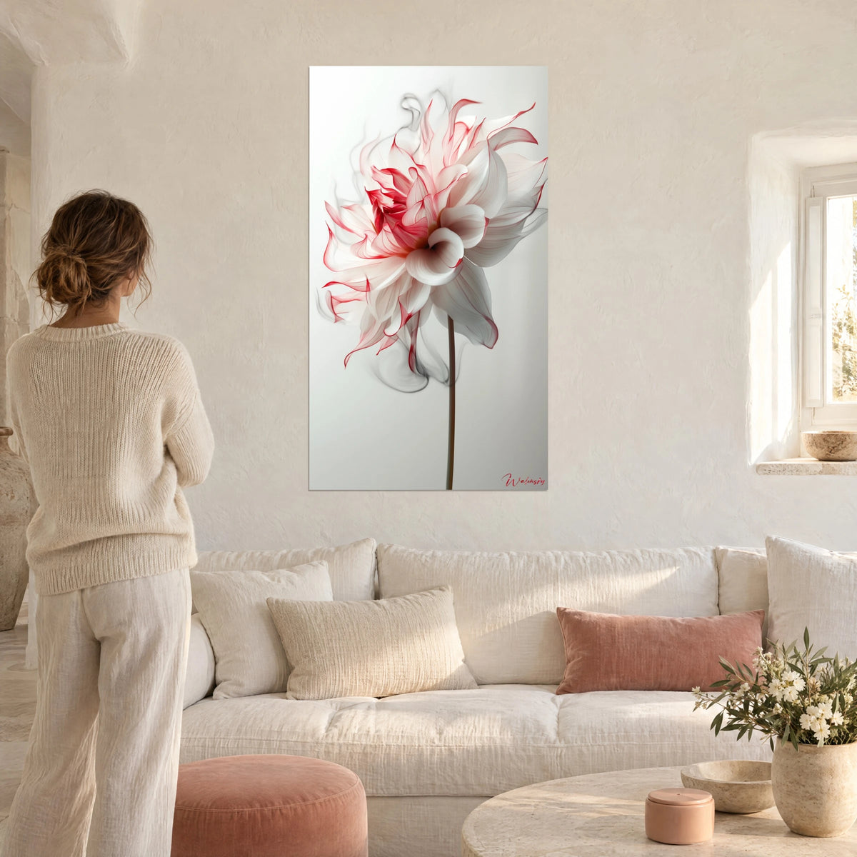 Gemälde Dahlie mit weißen, karminrot umrandeten Blütenblättern, brauner Stiel, Frau von hinten, über einem Sofa in einem lichtdurchfluteten Wohnzimmer