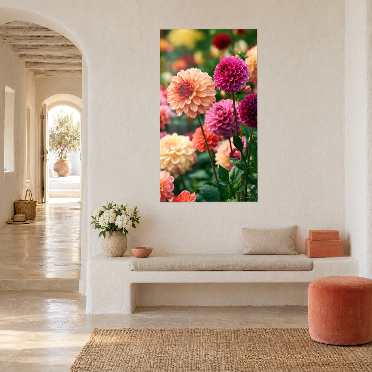 Wall art with a bed of fuchsia and orange dahlias against a blurred green background, hung on the white wall of a Mediterranean house