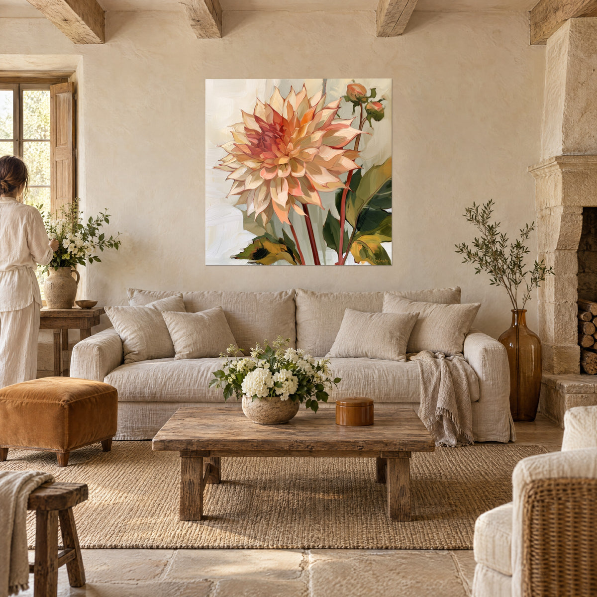 Tableau dahlia aux pétales crème et corail déployés, feuilles vert olive, deux personnes de dos, au-dessus d'un canapé dans un salon lumineux
