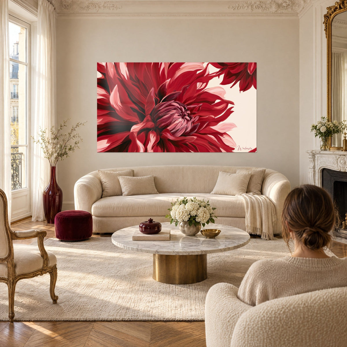 Tableau dahlia rouge carmin aux pétales rose pâle déployés, fond crème, deux personnes de dos, au-dessus d'un canapé dans un salon lumineux