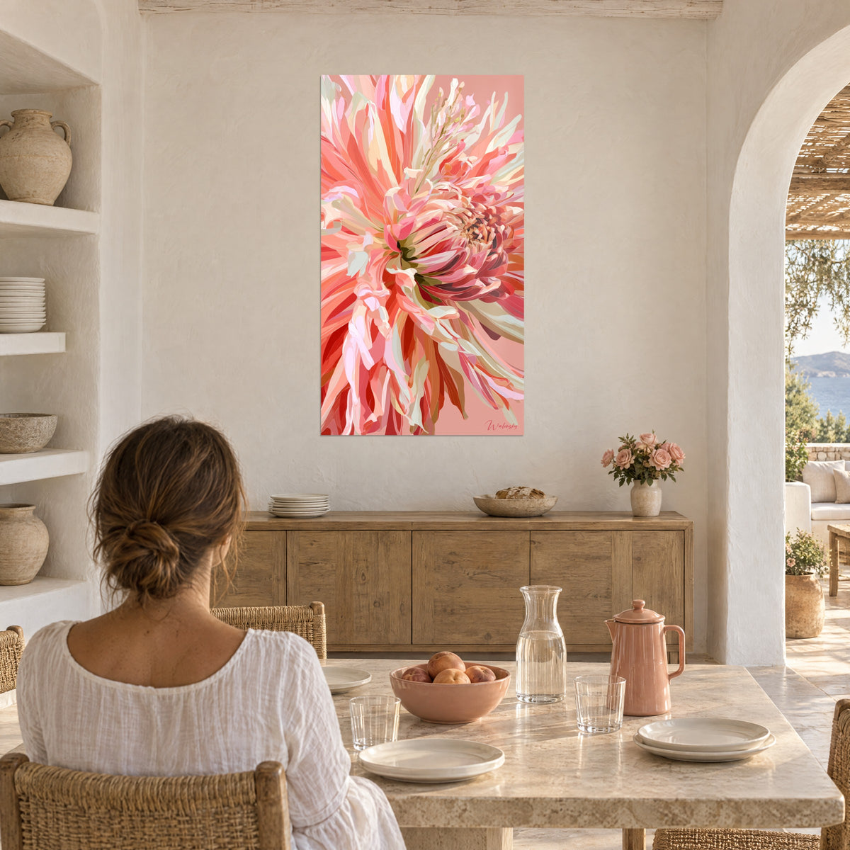 Quadro bouquet di petali rosa pallido e rossi, fondo salmone, donna di spalle seduta a un tavolo sotto le volte bianche di una casa mediterranea