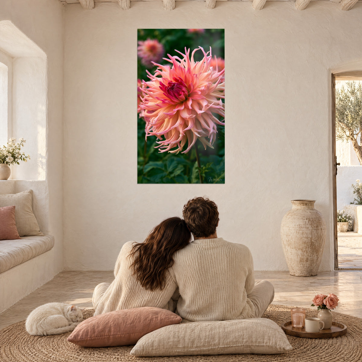 Schilderij dahlia met lange crèmeroze bloemblaadjes en karmozijnrood hart, stel van achteren op kussens, witte woonkamer in Mediterrane stijl