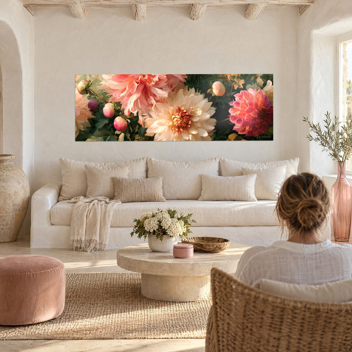 Quadro grande dalia color crema con cuore zafferano circondata da petali rosa corallo e fogliame verde scuro, sopra un divano in un soggiorno luminoso