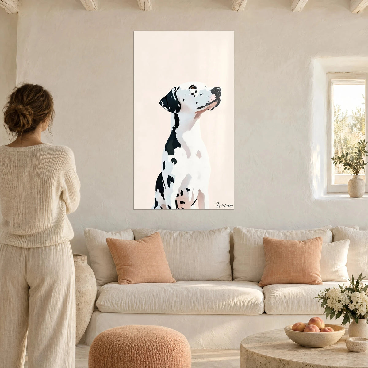 Quadro dalmata con il muso alzato, pelo bianco macchiato di nero su sfondo rosa pallido, sopra un divano in un soggiorno luminoso