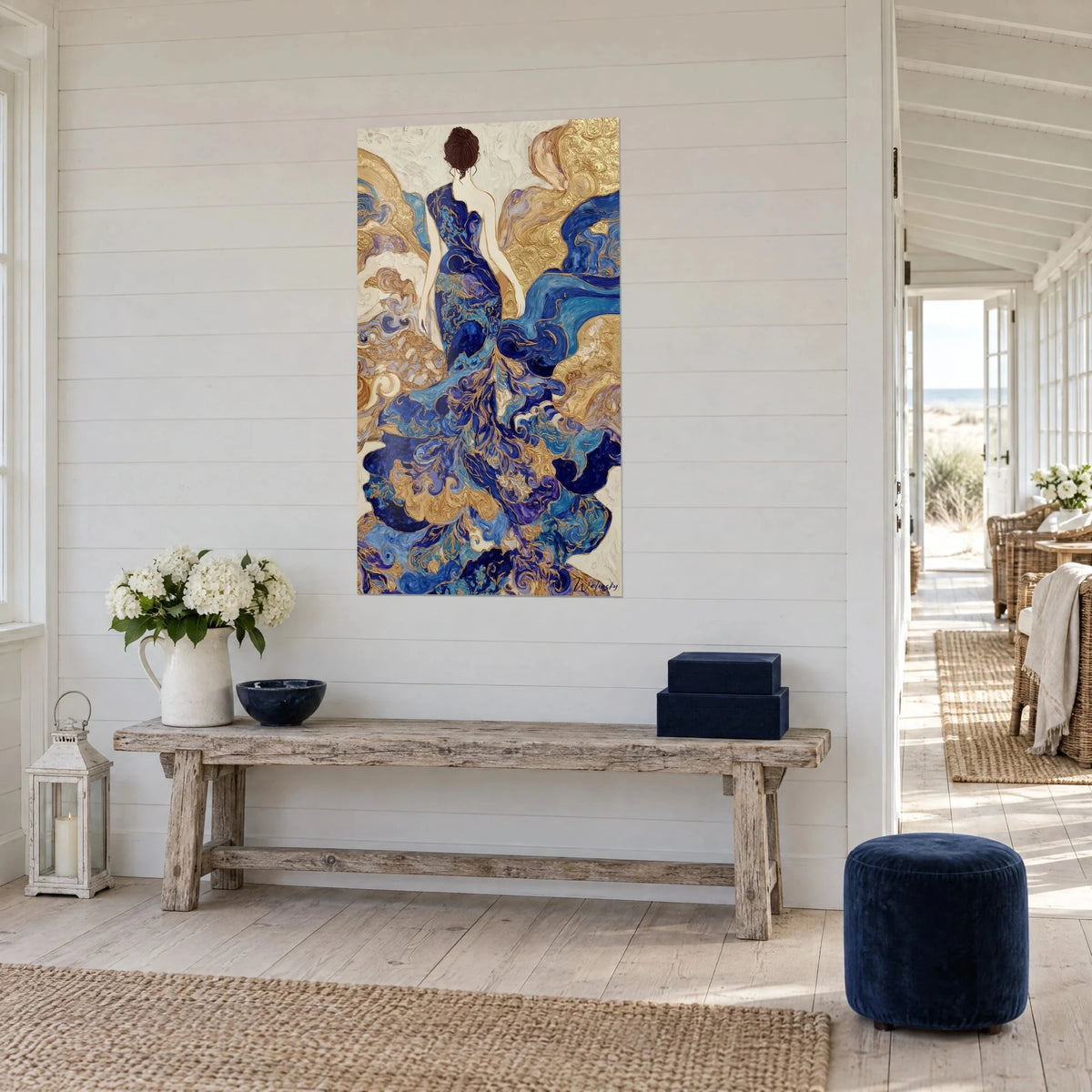 Quadro silhouette femminile drappeggiata con strascico blu cobalto e oro su fondo color crema, parete di lamelle bianche, panca in legno grezzo