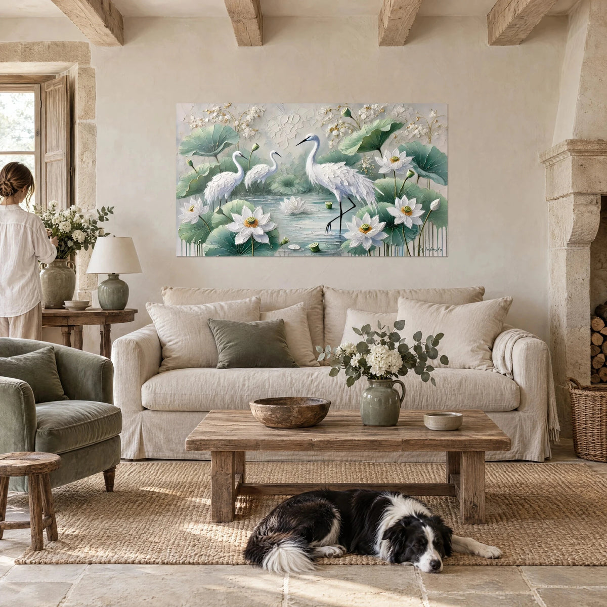 Gemälde weiße Kraniche zwischen zartrosa Lotusblüten und salbeigrünen Blättern, Frau von hinten, Collie, über einem Sofa in einem hellen Wohnzimmer
