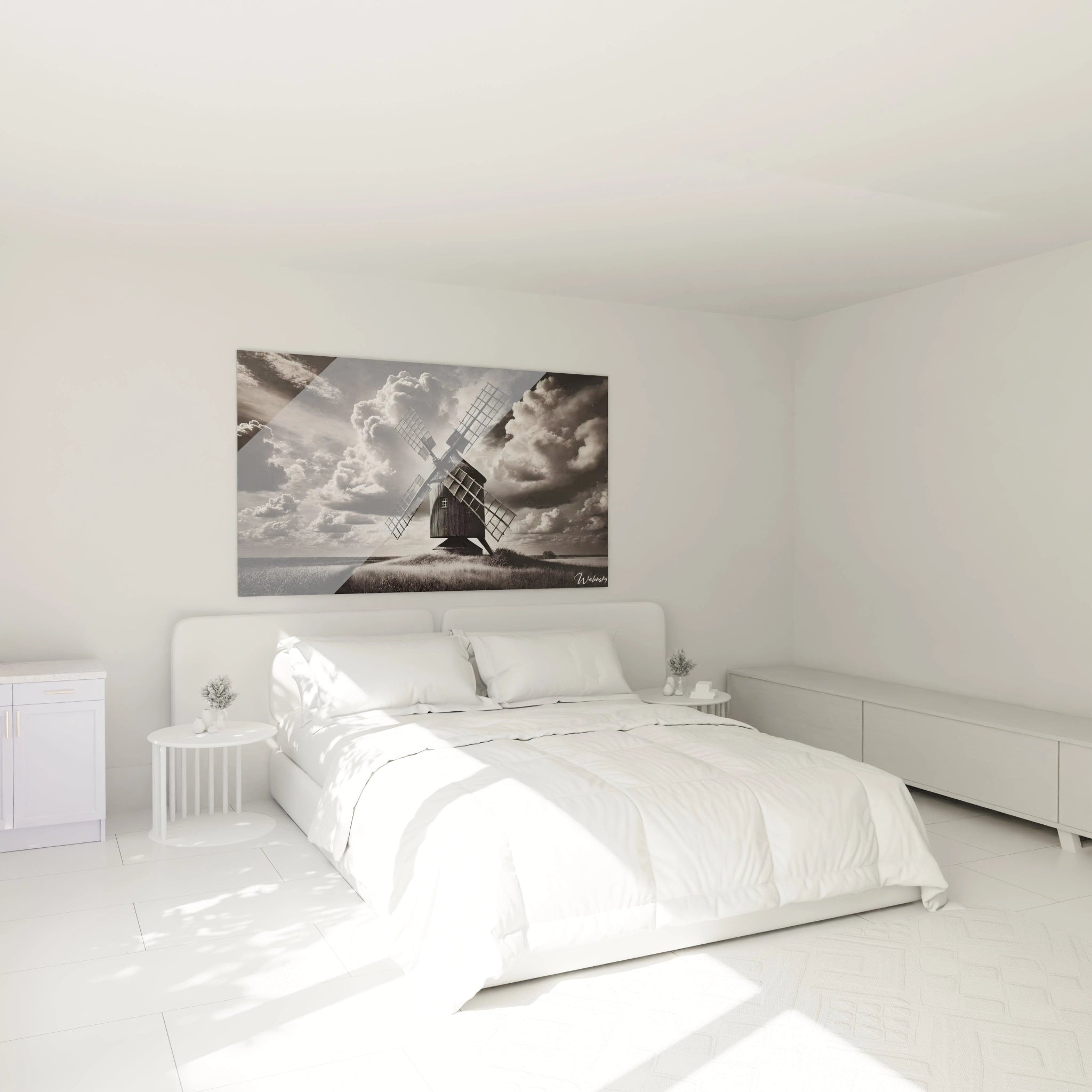 Tableau noir et blanc au-dessus du lit dans une chambre paisible capturant un moulin et des nuages lourds pour une ambiance serene et introspective.
