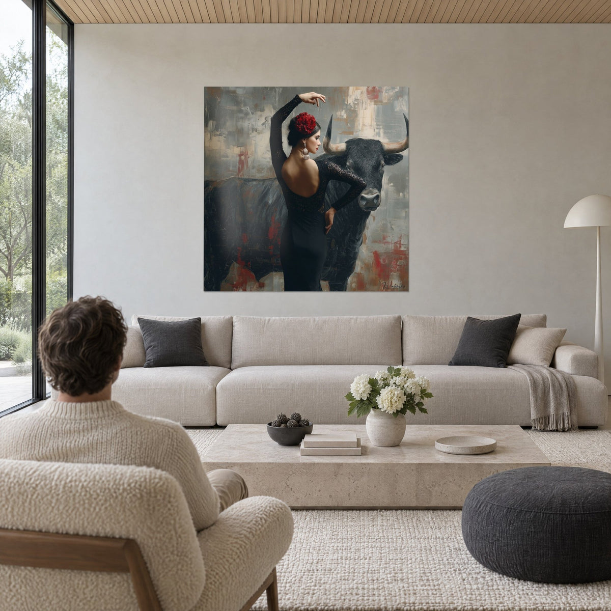 Tableau danseuse flamenco en robe noire dentelle, bras levé, fleur rouge, taureau gris charbon, au-dessus d'un canapé dans un salon lumineux