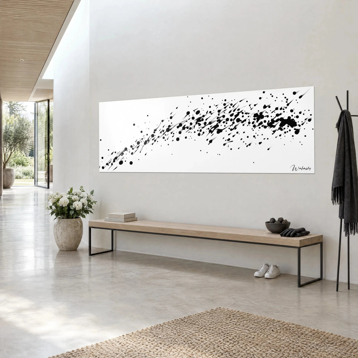 Quadro con gocce nere proiettate in scia su bianco brillante, formato panoramico, parete grigio chiaro, panca in legno, sopra una panca in un ingresso