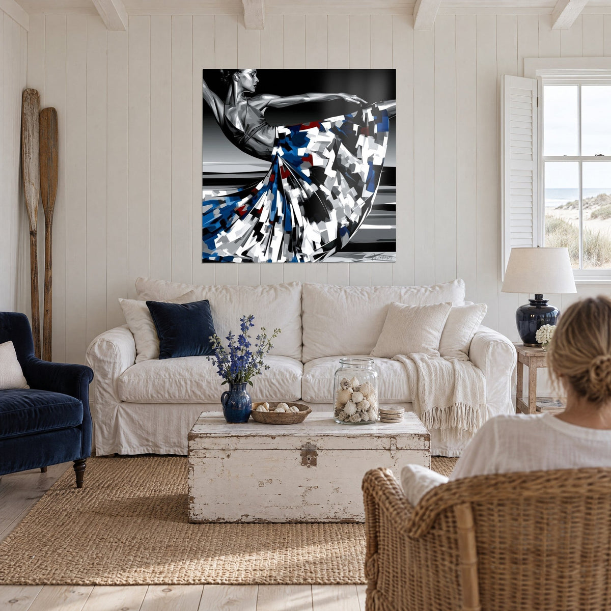 Schilderij danseres in een boog, uitgestrekte arm, jurk met blauwe en witte ruitjes, zwarte achtergrond, boven een bank in een lichte woonkamer