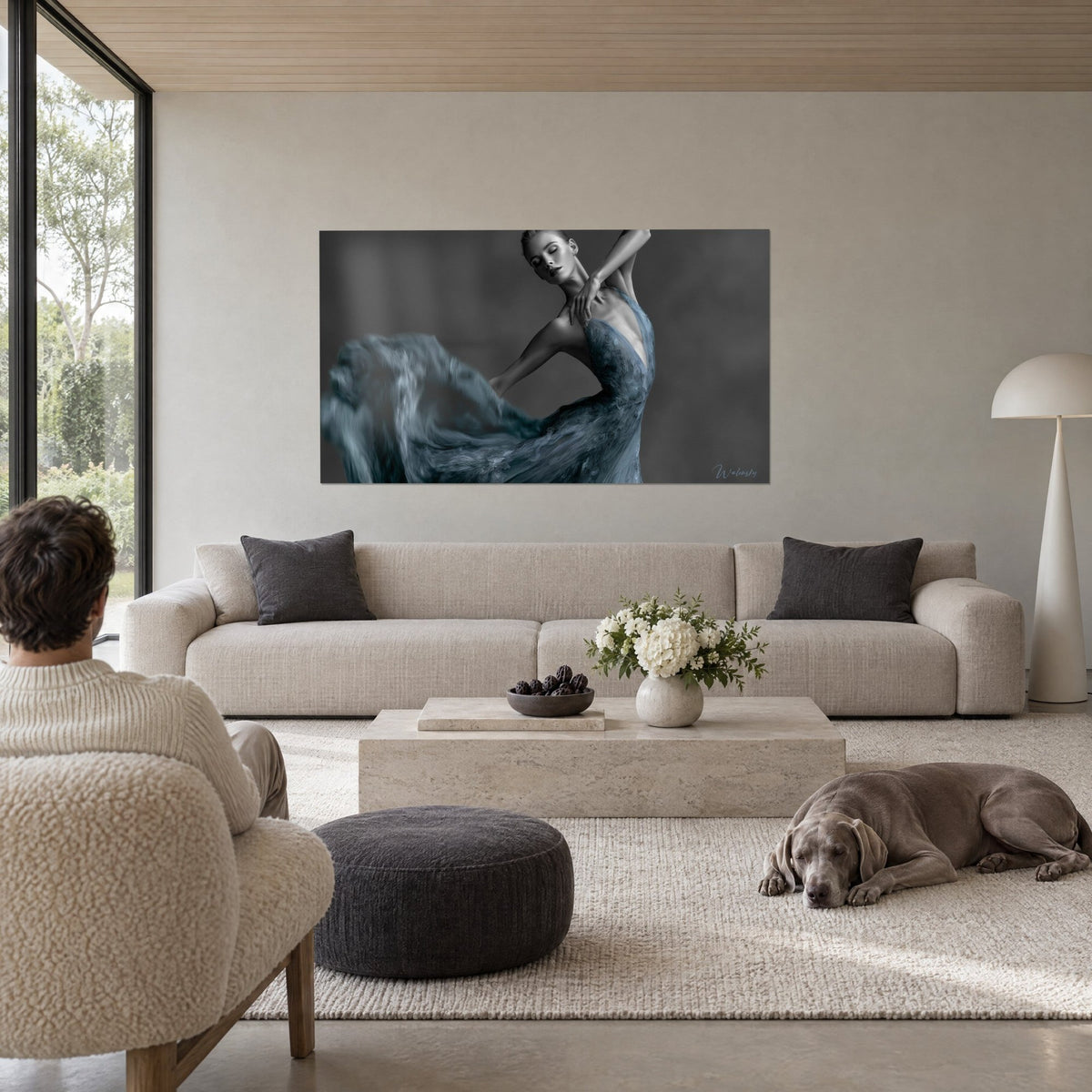 Tableau danseuse aux paupières closes, bras repliés sur l'épaule, robe bleu acier tourbillonnante sur fond gris, au-dessus d'un canapé dans un salon lumineux