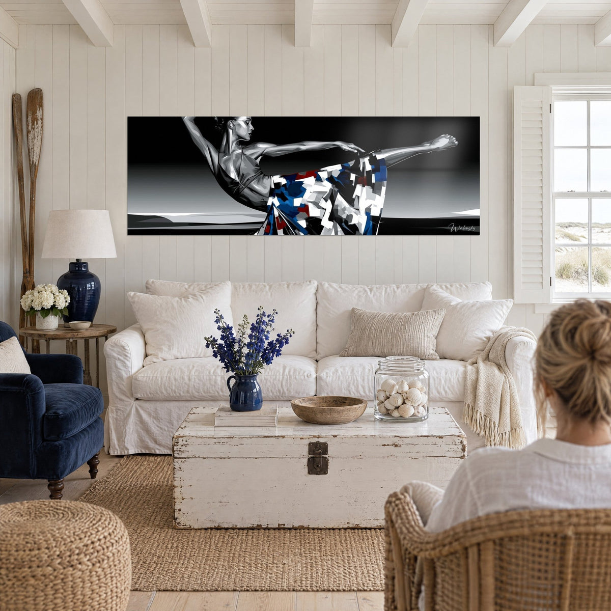 Quadro ballerina in equilibrio, gonna a quadrati blu, rossi e bianchi su fondo nero, sopra un divano in un soggiorno luminoso