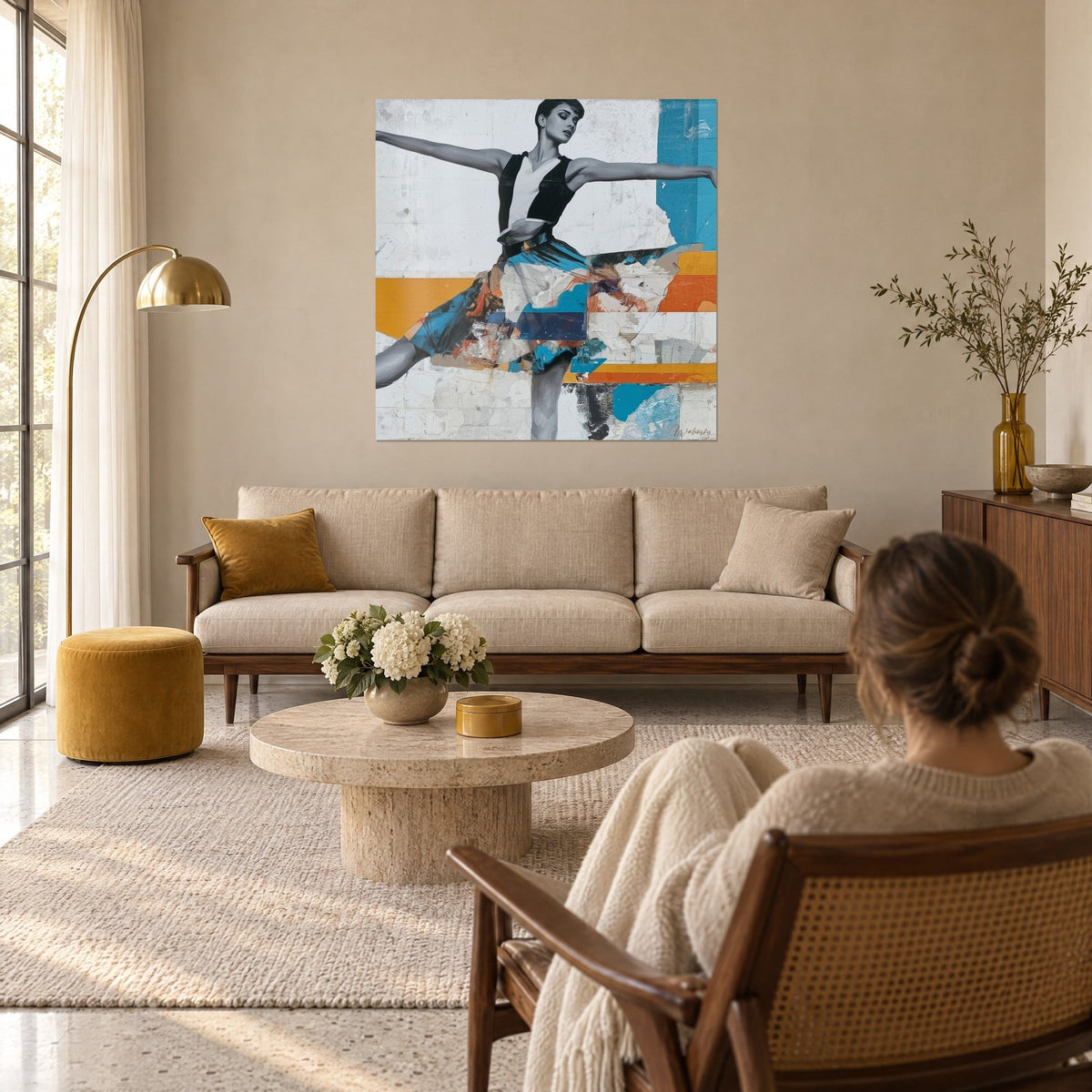 Tableau ballerine en grand jeté, jupe bleu turquoise et orange, bandes ocre, vue par une femme, au-dessus d'un canapé dans un salon lumineux