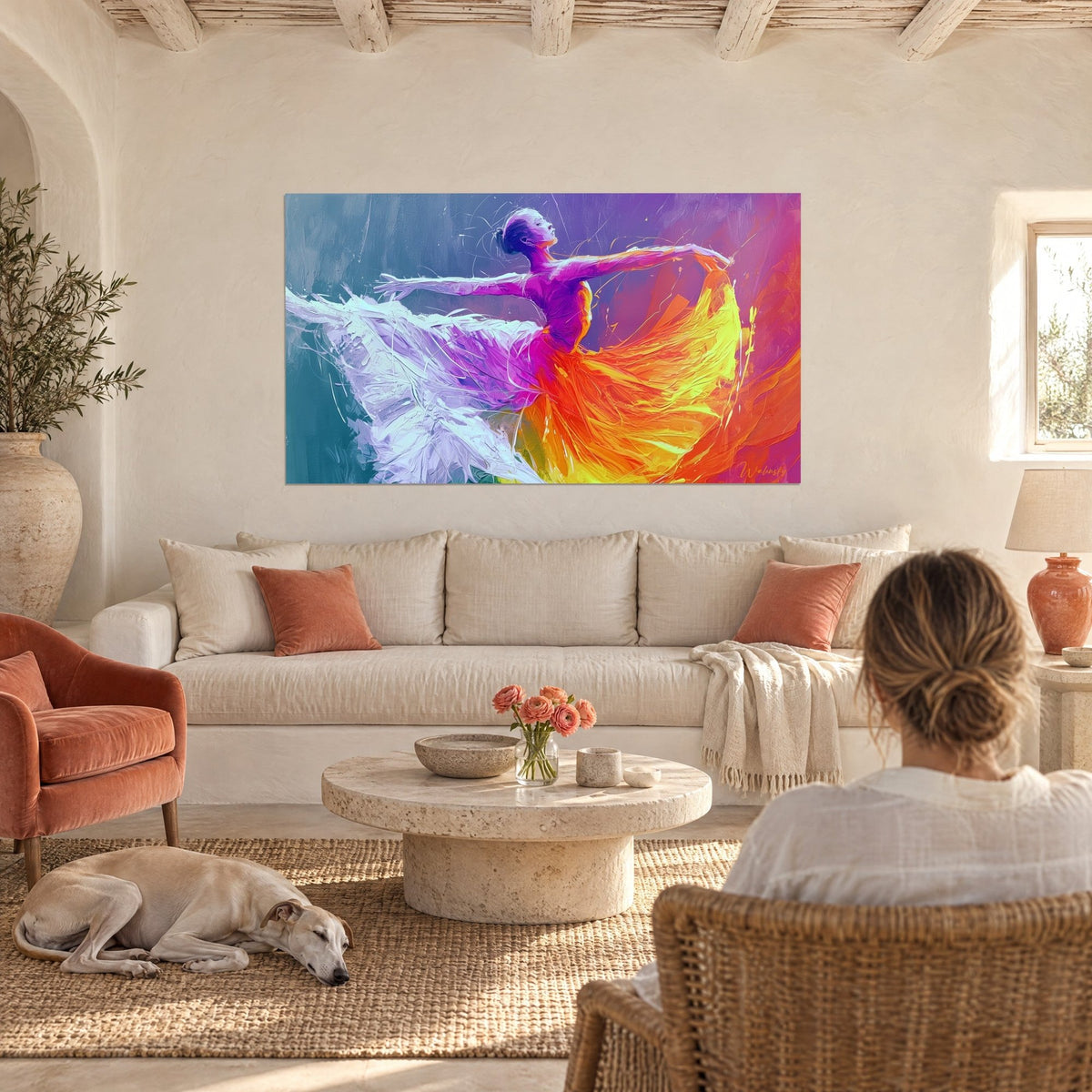 Cuadro bailarina con los brazos extendidos, falda naranja y amarilla en volutas, tutú blanco lila, sobre un sofá en un salón luminoso