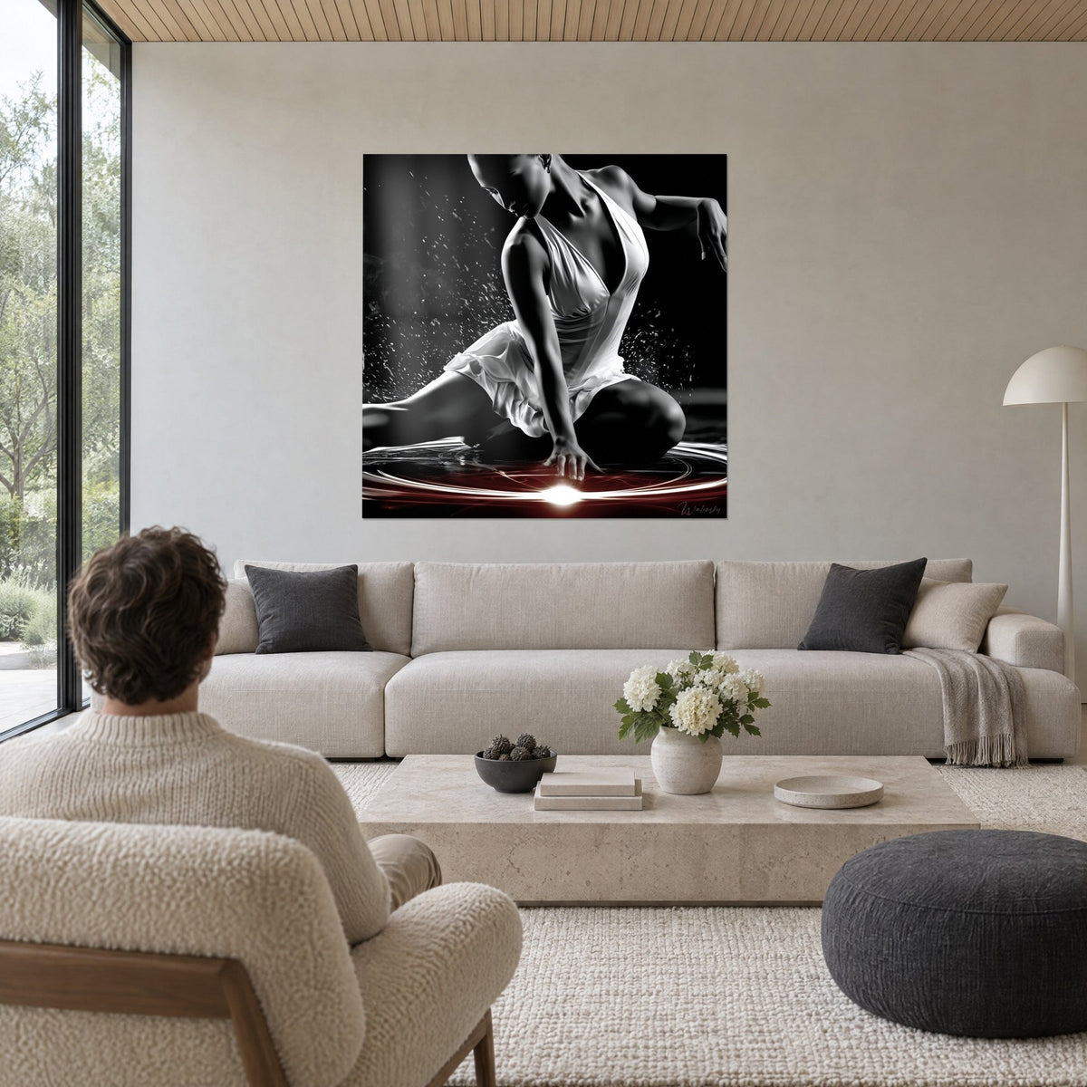 Tableau danseuse en robe blanche accroupie, éclat rouge et blanc au sol en noir et blanc, au-dessus d'un canapé dans un salon lumineux