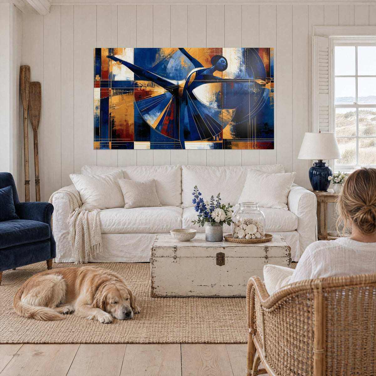 Tableau danseuse bleu cobalt à la jambe tendue, robe en éventail dorée, au-dessus d'un canapé dans un salon lumineux