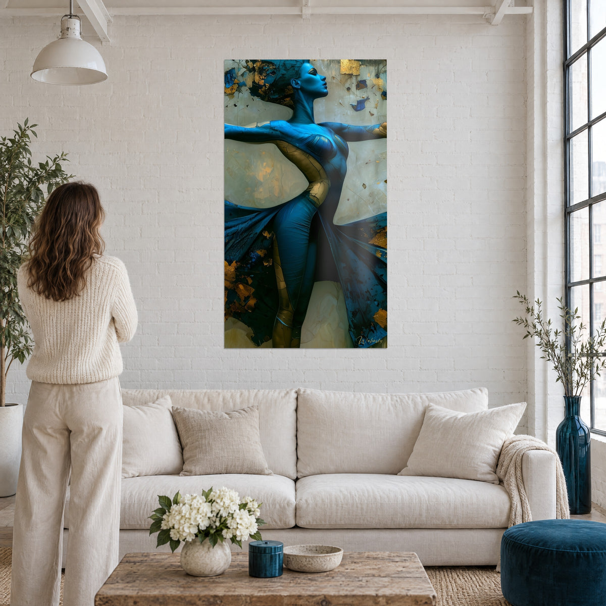 Wall art blue dancer with arms open, crackled skin in gold, draped ivory wings, above a sofa in a bright living room