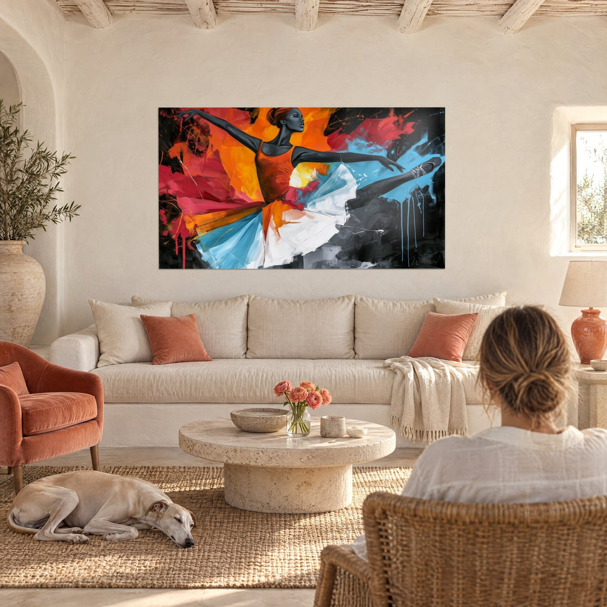 Tableau ballerine en arabesque, tutu bleu et blanc sur fond orange et rouge, deux personnes de dos, au-dessus d'un canapé dans un salon lumineux