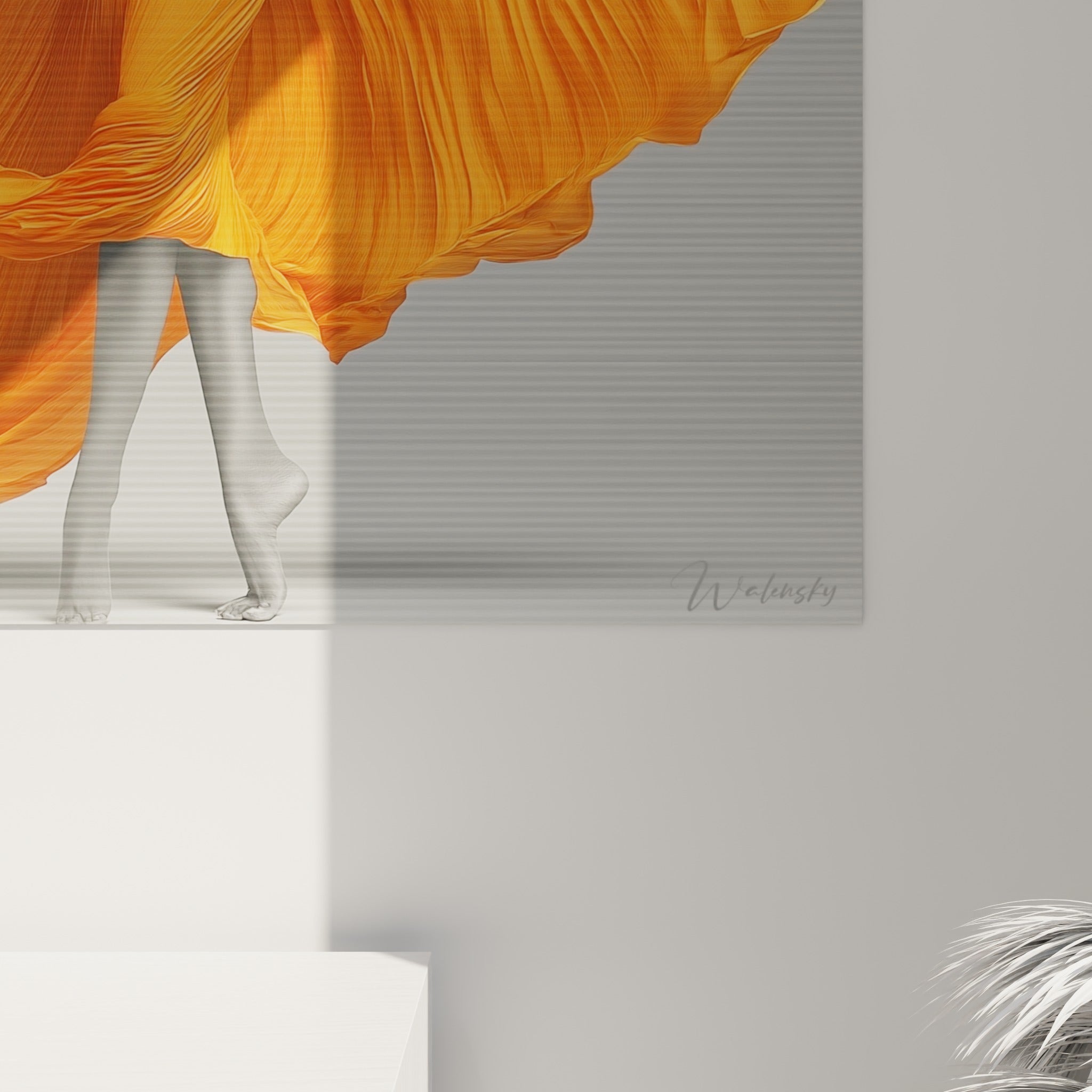 Plis serrés du tissu orange saturé contre la texture grise granuleuse du fond, détail rapproché de la toile