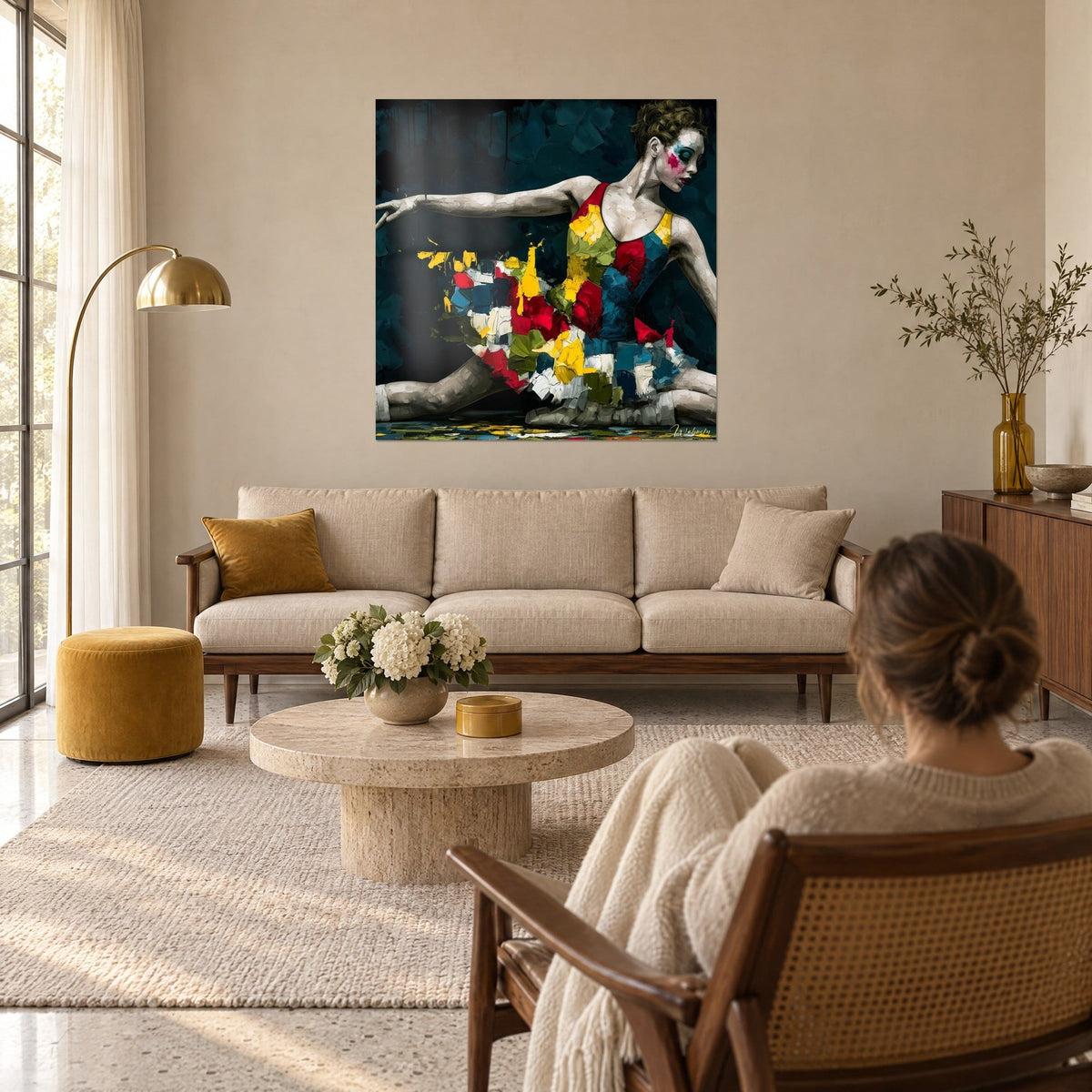 Tableau danseuse au bras tendu, tutu de touches rouges, jaunes et vertes sur fond bleu nuit, au-dessus d'un canapé dans un salon lumineux
